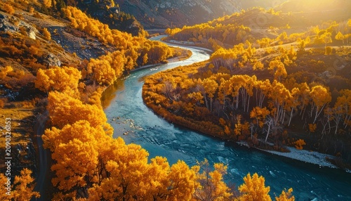 A winding river flows through a valley filled with vibrant golden autumn foliage under warm sunlight.