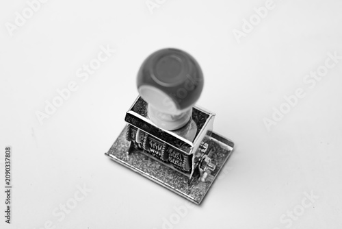 Close-up of a vintage manual date stamper in black and white on white background