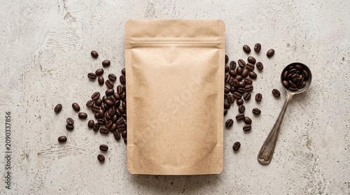 Blank brown kraft paper pouch mockup with roasted coffee beans and measuring spoon on textured background for packaging design presentation