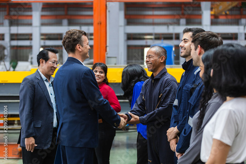 Bild auf Leinwand Diverse business team having happy meeting and agreement with factory worker and