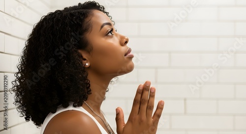 Peaceful young African American woman praying for hope and spiritual faith