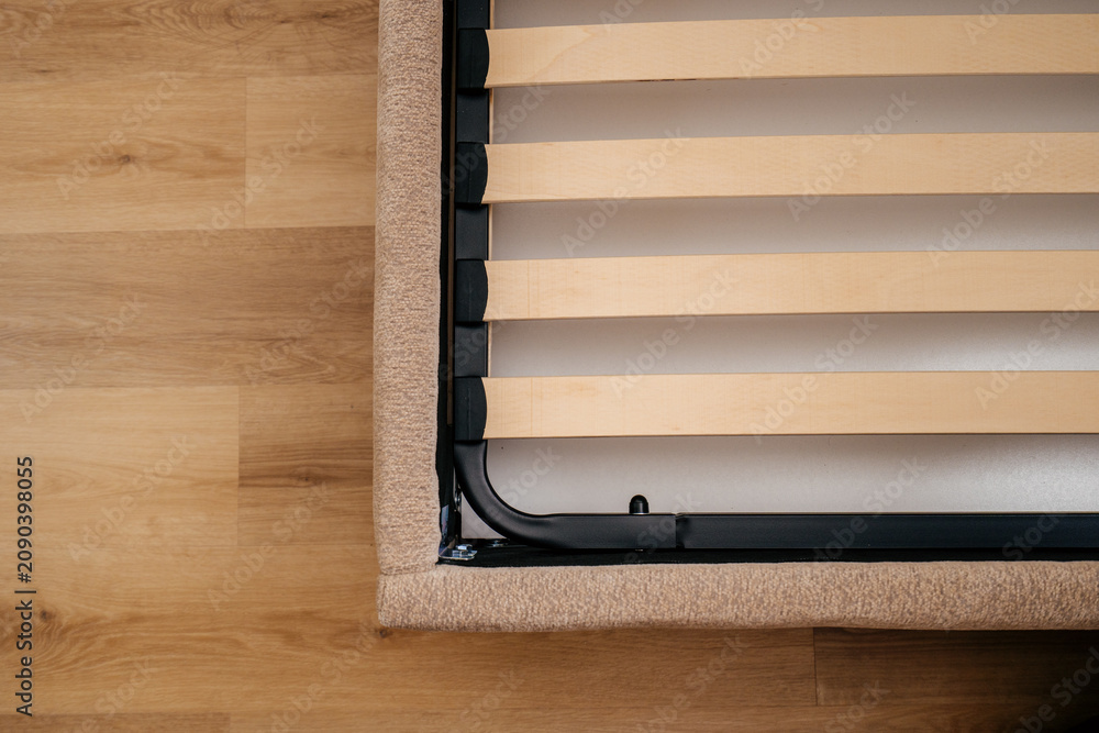 Obraz premium New wooden slats are placed on the bed base in a bedroom for support and comfort