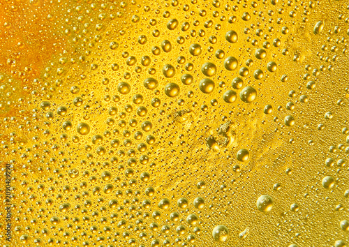 Macro shot of water droplets on a cold, vibrant yellow background, creating a refreshing texture.
