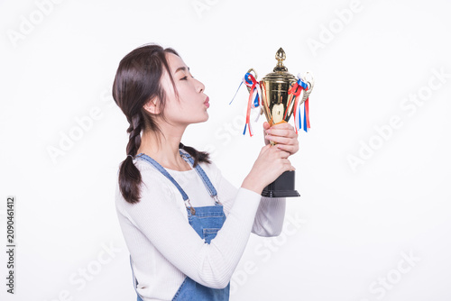 Young woman kissing trophy and celebrating victory