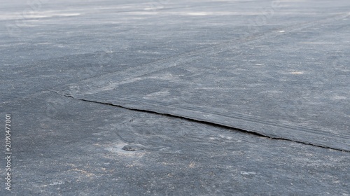 Lifted seam on the roof. Asphaltic bitumen is a kind of coating for roof to make it waterproof