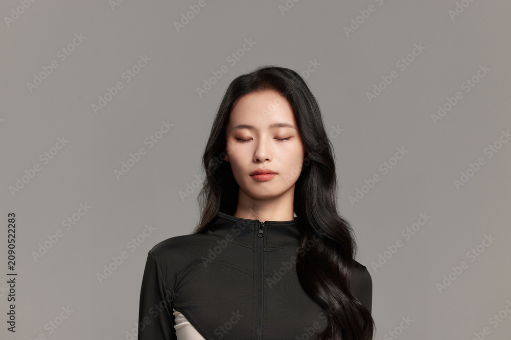 Fototapeta premium Calm young woman in black futuristic outfit with eyes closed