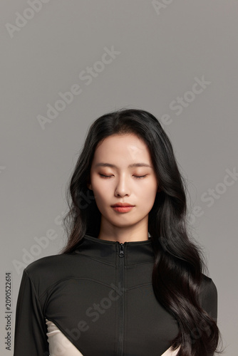Calm Young Woman in Black Outfit with Eyes Closed