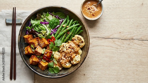 Colorful Vegetable Tofu Bowl Arranged on Light Wooden Table