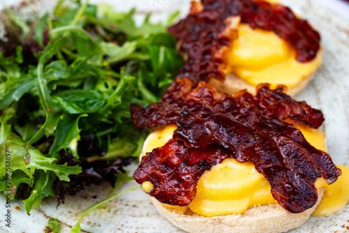 Bild auf Leinwand eggs benedict on toasted English muffins topped with crispy bacon