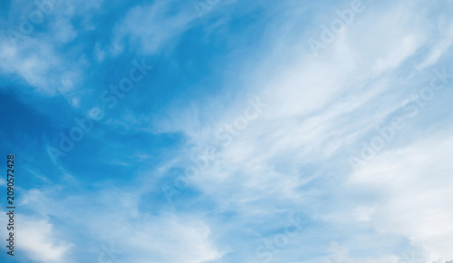 the sky is clear blue with fluffy white clouds, the sky is very bright, and the sun shines.