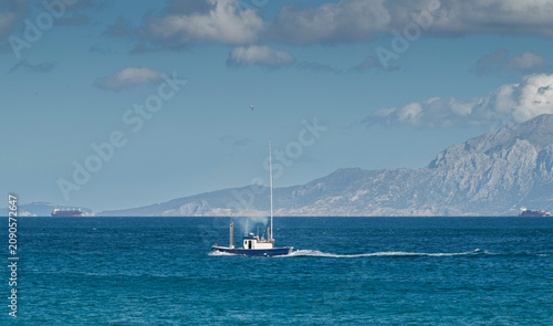 Foto Small fishing boat crossing the Strait of Gibraltar off Tarifa, Spain, with the