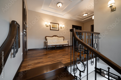 Photos Classical upper hallway with ornate wood staircase and luxury lounge area