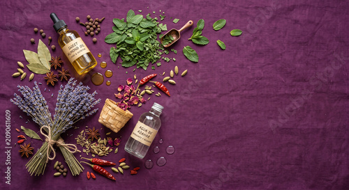 Flat lay of Lebanese orange blossom and almond oil beauty elements on purple fabric
