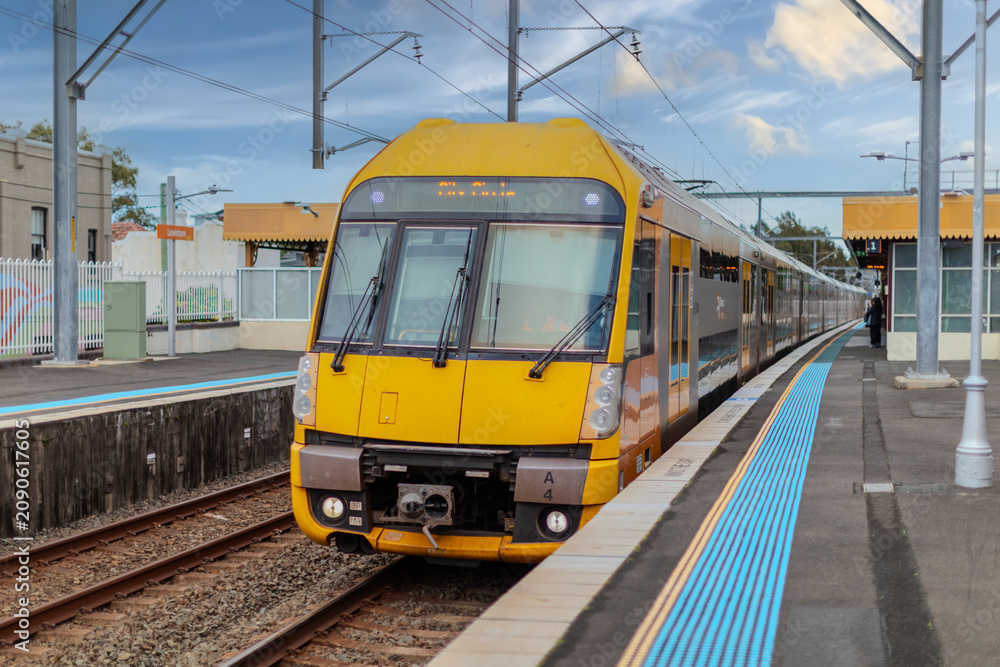 Obraz premium 7 July 2026 Passenger Train going through Lewisham Train Station at Sunset a suburban Sydney train Station in Sydney NSW Australia