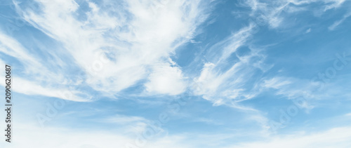 the sky is clear blue with fluffy white clouds, the sky is very bright, and the sun shines.