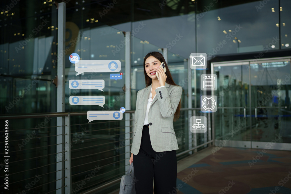 Fototapeta premium Businesswoman Talking on Phone at Airport with Digital Communication Icons and Message Notifications Overlay