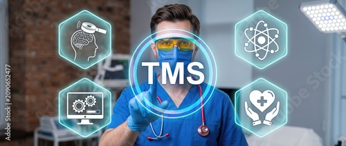 Healthcare professional in blue scrubs using advanced technology for patient care with digital graphics representing medical concepts and treatment methods