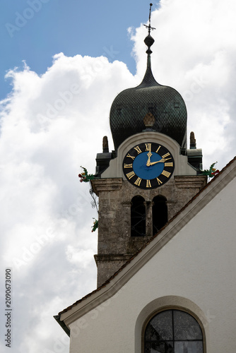 Historic church tower with ornate dome and clock face in Eglisau, Switzerland