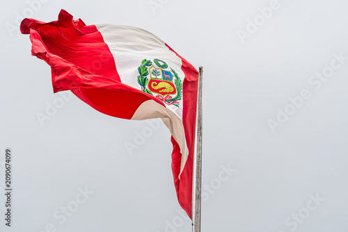 Foto Peruvian Flag with National Emblem Waving in the Wind