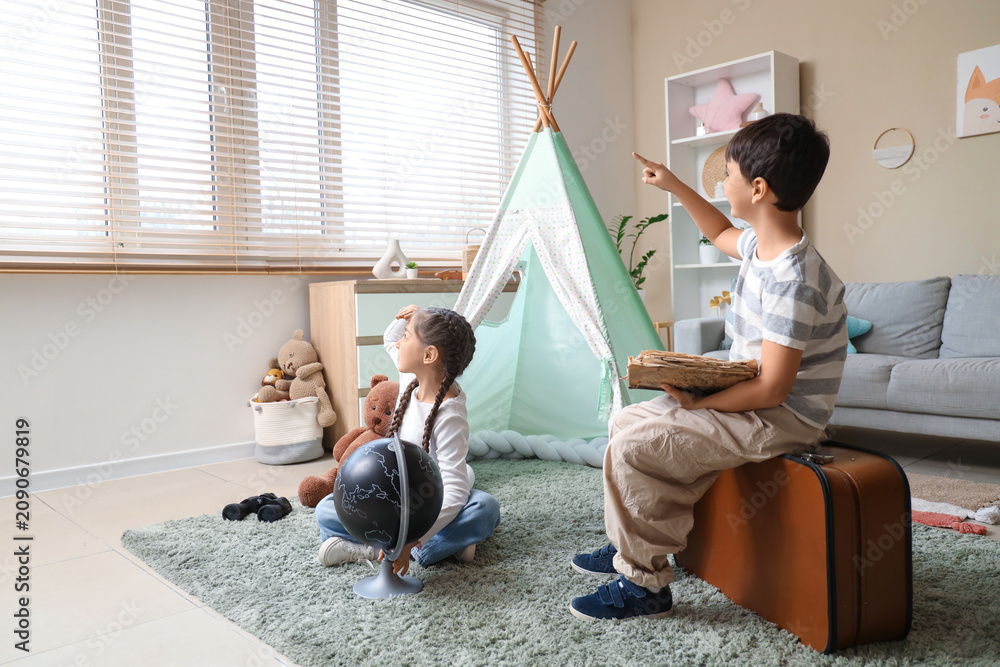Obraz premium Cute children with adventure book pointing at something in room
