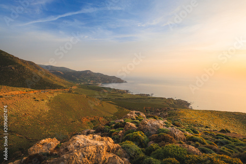 Golden sunset over the western coast of Crete Greece with rocky cliffs Mediterranean sea
