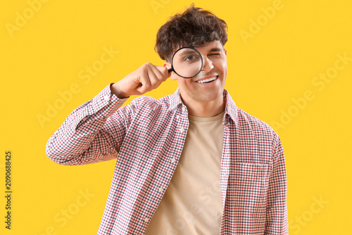 Young man with magnifier on...