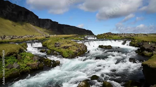 Breathtaking landscape with waterfall streams against a backdrop of picturesque clouds in Iceland.