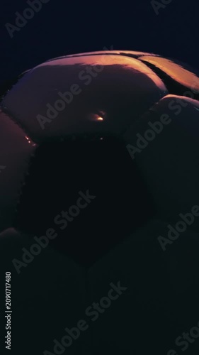 Rotating soccer ball close up on dark blue background