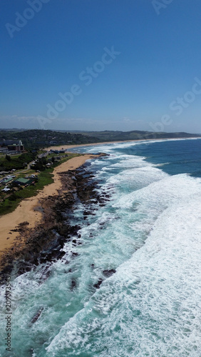 Aerial view of coastal town of Scottburgh residential area and white beach, deep blue ocean and waves.  Location South Coast of KwaZulu-Natal.  Vertical image