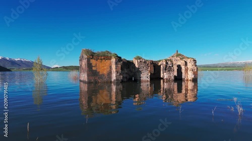 Aerial view old, abandoned  church in Aparan rezervior in Armenia, West Asia. Exploring old stone ruins in a lake . Old stone ruins stand in a lake. 