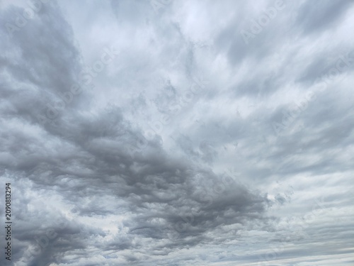 Dramatic textured background of dark storm clouds rolling across an overcast sky