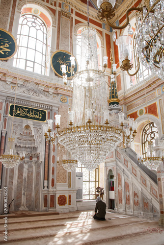 Ornate interior of Ortakoy Mosque with crystal chandeliers and marble mihrab in Istanbul, Turkey