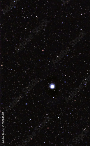 Bright star Vega shining in a dense night sky full of stars.