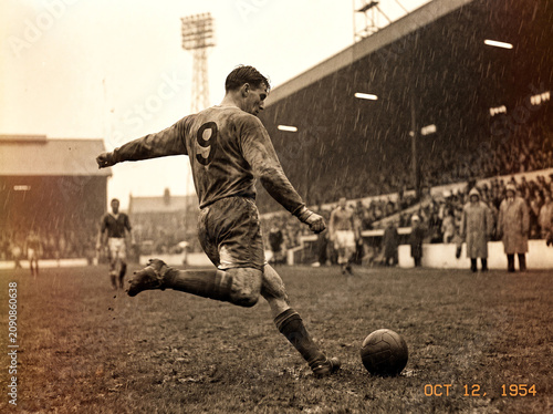 Vintage Soccer Player Action Shot Kicking Ball in Heavy Rain