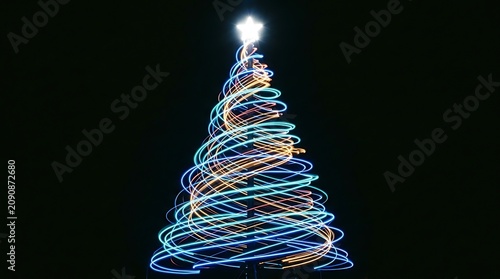 Abstract christmas tree formed by spiraling blue and orange light trails on black background