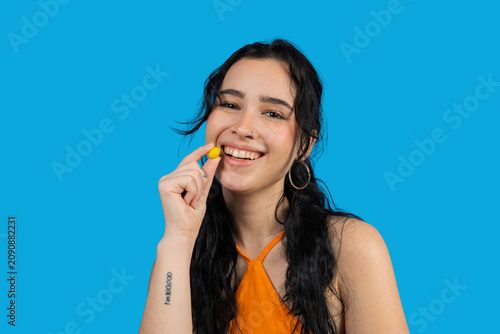 Young woman smiling and holding yellow candy