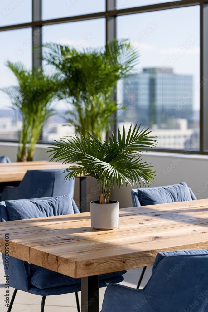Fototapeta premium Modern office table with small potted palm for workspace background and biophilic sustainable interior design