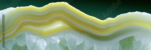 Close-up agate geode crystal slice with yellow green bands and white crystalline edge for abstract background and wallpaper texture design