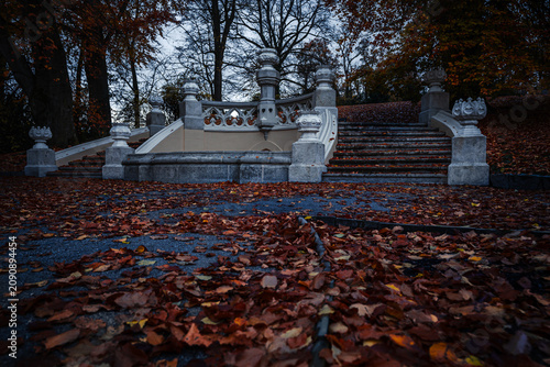 Historic staircase surrounded by autumn leaves with atmospheric mood in the gardens of Hluboka nad Vltavou Castle, Czech Republic.