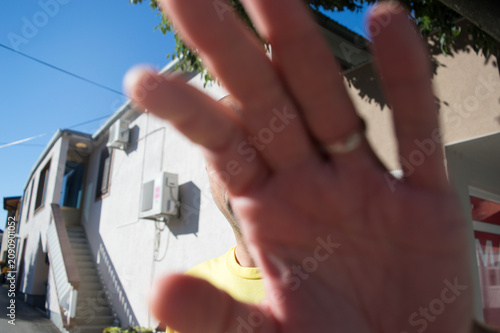 Person covering camera with hand to protect privacy and refuse photography