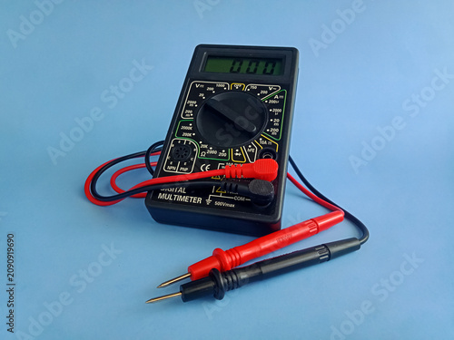 Obraz na plátně Electronic digital multimeter with probes on blue background