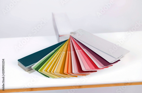 color swatch book fanned out on white surface with wooden edge. High quality photo
