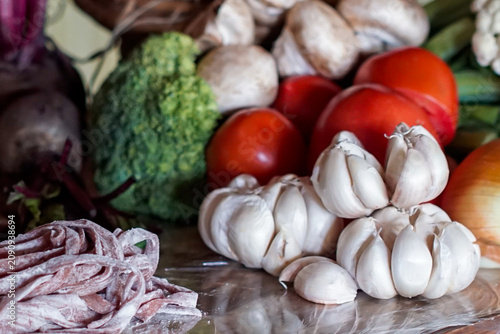 Cuadro en lienzo Close up of fresh garlic with vegetables and raw pasta on rustic table