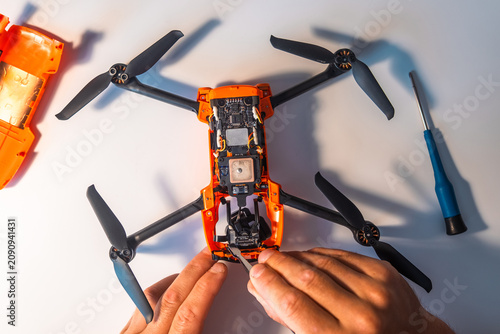 A man repairs a broken quadcopter.