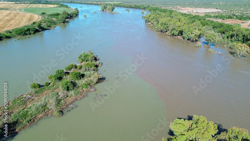 Aerial view of the confluence of the Vaal river and the Orange river south of the town of Douglas, Northern Cape, where brown and green river water merge