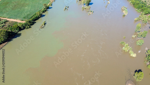 Aerial view of the confluence of the Vaal river and the Orange river south of the town of Douglas, Northern Cape, where brown and green river water merge