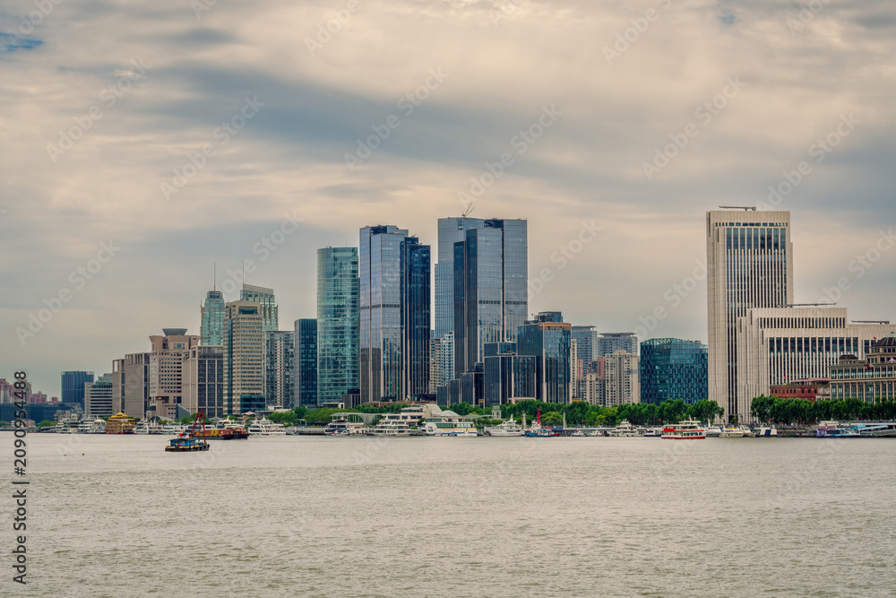 Obraz premium Modern Waterfront Skyline and Corporate High-Rises Along the Huangpu River Under an Overcast Sky in Shanghai, China