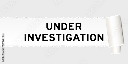 Ripped gray paper background that have word under investigation under torn part
