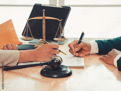 Fotografía Lawyer holding pen and explaining legal contract terms on clipboard to client during consultation in law firm