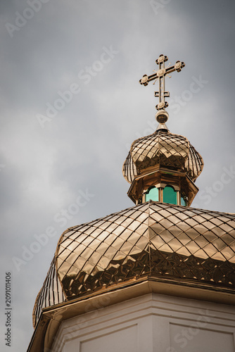 Cuadro en lienzo Golden onion dome of orthodox church with ornate cross under stormy sky